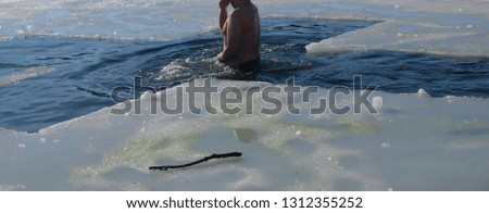 A man bathes in ice water in a winter walrus.