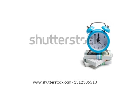 A clock is standing on a bunch of packs of money on a white background. The concept of expressing time is money. Planning time and increase efficiency, increase profits. Side job in free time.