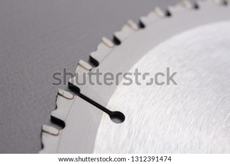 New aluminum cutting disc. Cutting knife for manual chainsaw. Dark background.