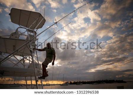 Silhouette of a man on a boat with clouds in the background