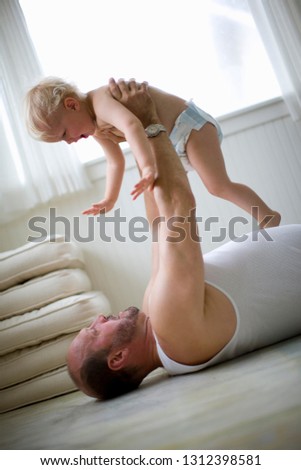 A toddler playing with his father