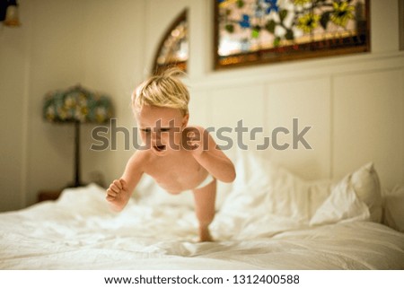 Little boy jumping on bed