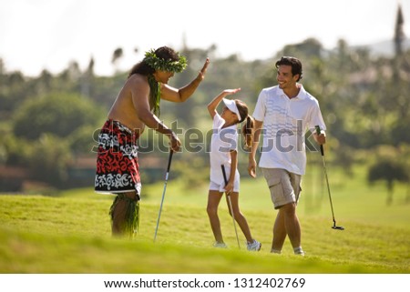 Girl at a golf course doing a high five with man dressed in Hawaiian costume.