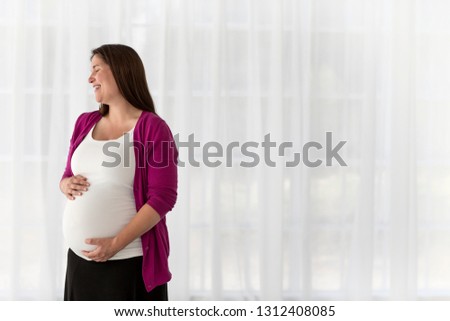 Pregnant woman rubbing belly.