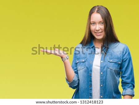 Young caucasian beautiful woman over isolated background smiling cheerful presenting and pointing with palm of hand looking at the camera.