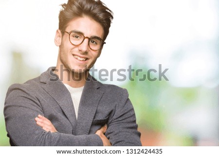 Young business man wearing glasses over isolated background happy face smiling with crossed arms looking at the camera. Positive person.
