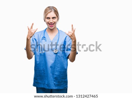 Young beautiful blonde doctor surgeon nurse woman over isolated background shouting with crazy expression doing rock symbol with hands up. Music star. Heavy concept.