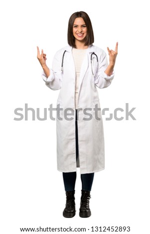 A full-length shot of a Young doctor woman making rock gesture over isolated white background