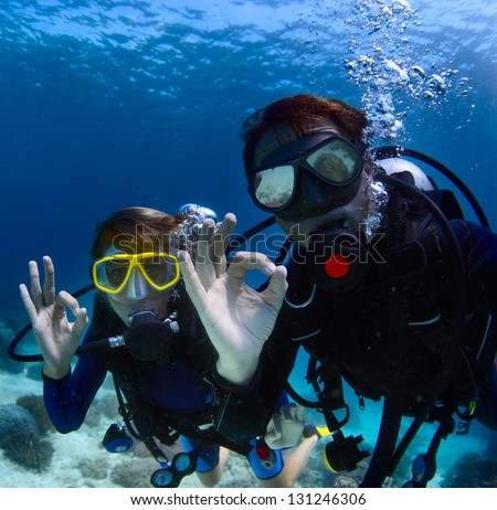 Scuba divers underwater showing ok signal