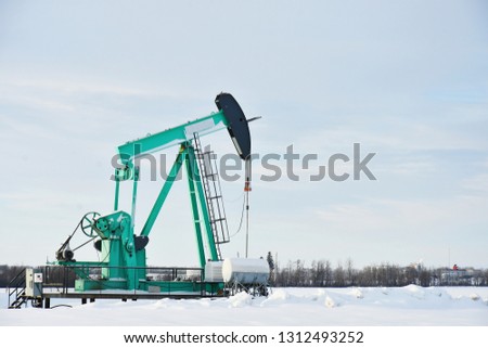 An image of a working pump jack in winter. 