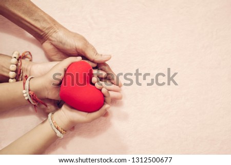 Group of hands holding red heart for V-Day love for valentine concept.