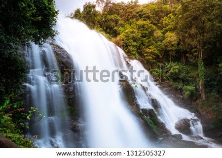 Flowing waterfall in mountain taken in low shutter speed, name Wachirathan waterfall. Chiangmai, Thailand
