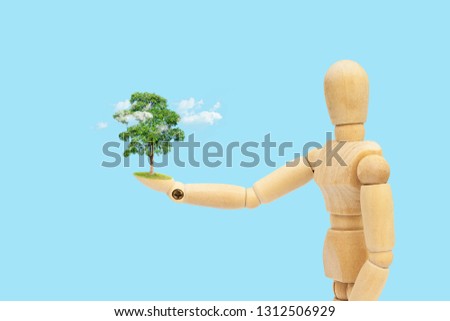 Ecology Concept : Wooden figure mannequin holding green tree and white cloud in hand.
