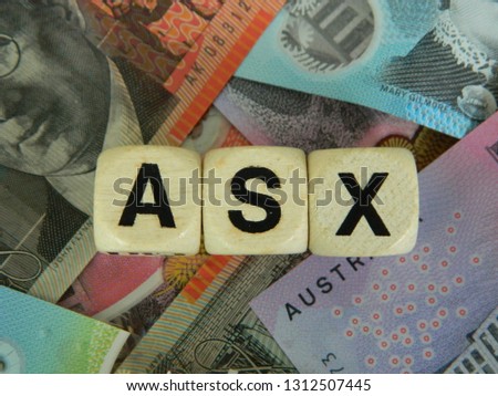ASX spelled out using gaming blocks on an Australian currency background