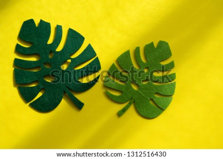 Decoration of fake leaf on yellow background. Minimalist concept