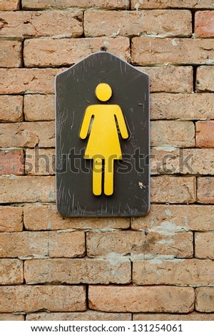 female toilet sign on the brick wall.