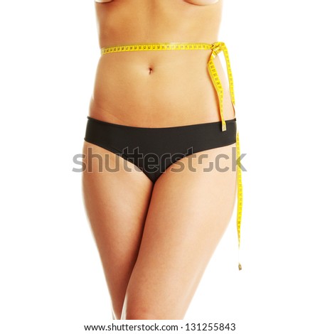 Slim woman with measuring tape on belly