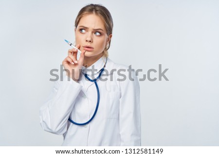  doctor with a stethoscope on the neck in hand syringe                              