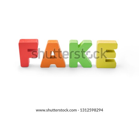 Wooden letters on white background - concept of fake information. Counterfeit and misinformation. Front view of colorful word FAKE isolated on white. False news. Distorted picture of situation