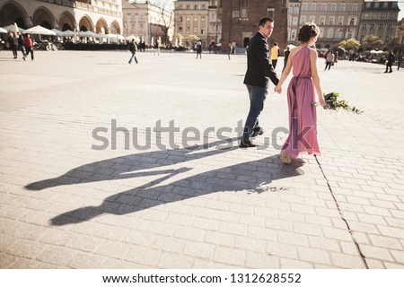 wedding. beautiful couple, bride with pink dress walking in the old city Krakow, their shadows
