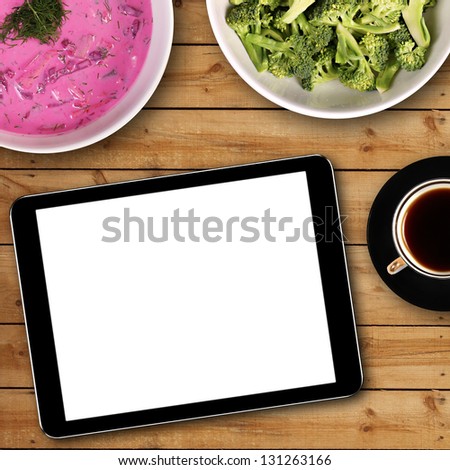 digital tablet with white blank screen on dinner table