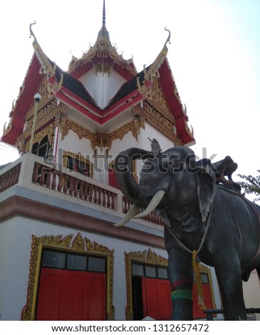 Hall of temple in red,black, gold, white with elephant sculpture in front, Nong Pho Temple, Nakhon Sawan, Thailand
