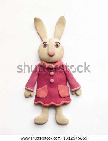 Cute hare in a pink dress. Plasticine character on a white background