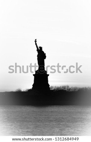 Backlight view of American symbol Statue of Liberty silhouette in New York, USA. High key black and white image.