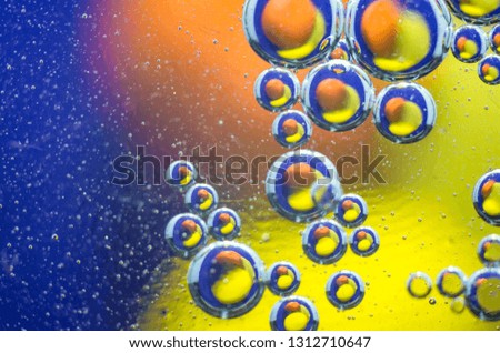Oil bubbles in the water over a colored background.