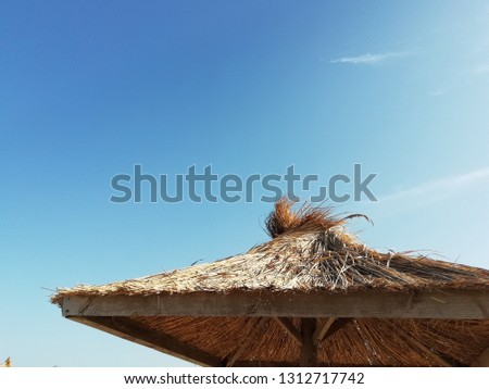 Thatched roof against the blue sky. Summer resort. Sea holiday.