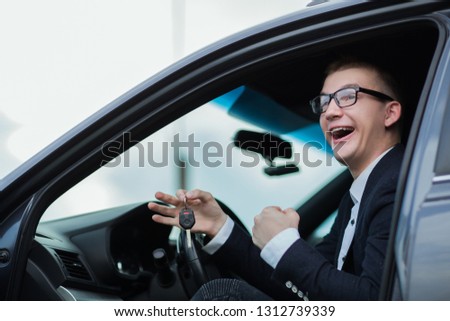cheerful businessman showing keys to his new car