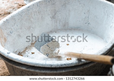 Close up of spade in a cement bucket which is used in construction.