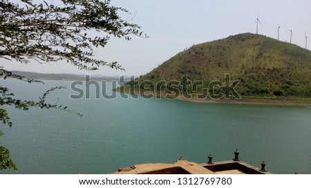 This image is captured at Vani Vilasa Sagara Dam. In this picture we can observe a beautiful mountain with windmills placed on them. 