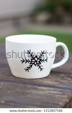 White ceramic sharpie mug with permanent marker drawing on wooden table diy cup gift snowflake drawing 