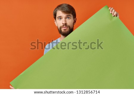 Bearded man with a green leaf on an orange background 