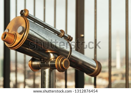 Touristic vintage paid telescope stands on the viewpoint of Hamburg, Germany. Close-up photo with tonal correction filter and soft selective focus