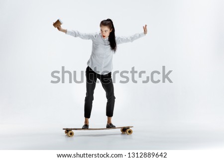 Businesswoman riding skate on white studio background. Flexibility, grace, elegance, balance and confidence in business. Human emotions concept. Office, success, professional concepts