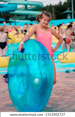 Girl on an inflatable circle in a blue water park, the concept of a summer holiday. Blue water in the pool, bright sun, rest on vacation