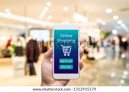 Smart phone online shopping in woman hand. Shopping center in background. Buy clothes shoes accessories with e commerce web site