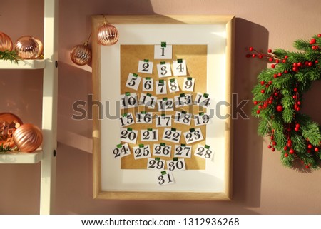 Frame with numbers hanging on wall in room. Christmas celebration