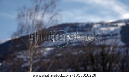 a soap bubble with the snow capped mountain and blue sky in background