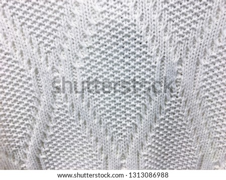 Beautiful texture of a soft warm natural sweater with a knitted pattern of threads. The background
