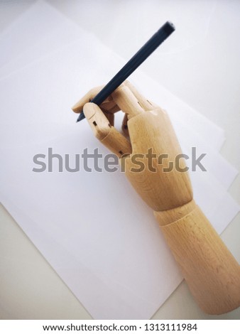 wooden hand writing on white sheet