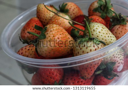 strawberry in clear plastic glass bowl