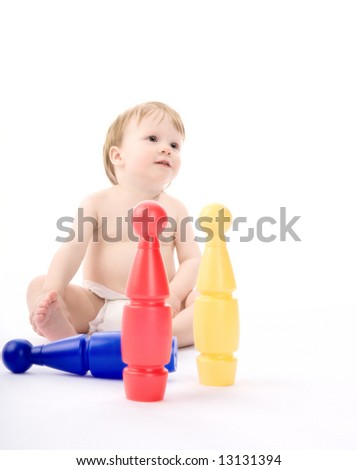 The little boy plays with ninepins. On a white background.
