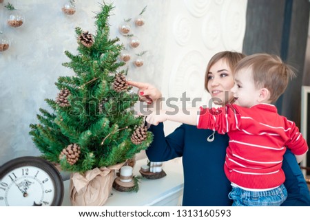 
beautiful mother with babies near the Christmas tree and fireplace