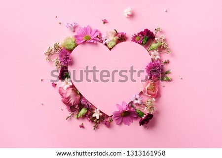 Creative layout with pink flowers, paper heart over punchy pastel background. Top view, flat lay. Spring, summer or garden concept. Present for Woman day. Royalty-Free Stock Photo #1313161958