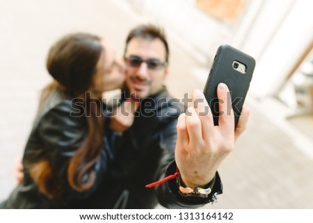 Couple in love doing a self-portrait selfie with the mobile phone.