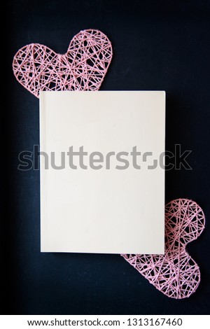 Two pink hearts from threads on a black background. Love. View from above. Empty sheet of paper, blank book cover