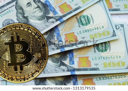 Golden Bitcoins on US dollars. Digital currency close-up. Crypto currency top view. Real coins of bitcoin on banknotes of one hundred dollars. Exchange. Bussiness, commercial.